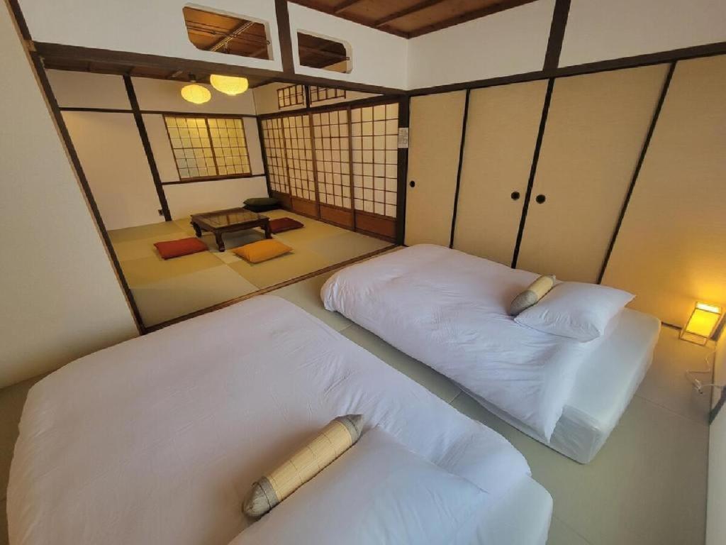 a room with two beds in a room with at Rinku Base Ichi in Tajiri