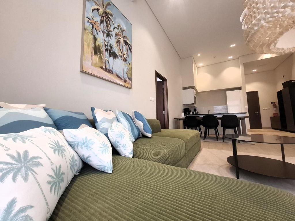 a living room with two couches and a dining room at Tulip River View in Ma‘mūrah