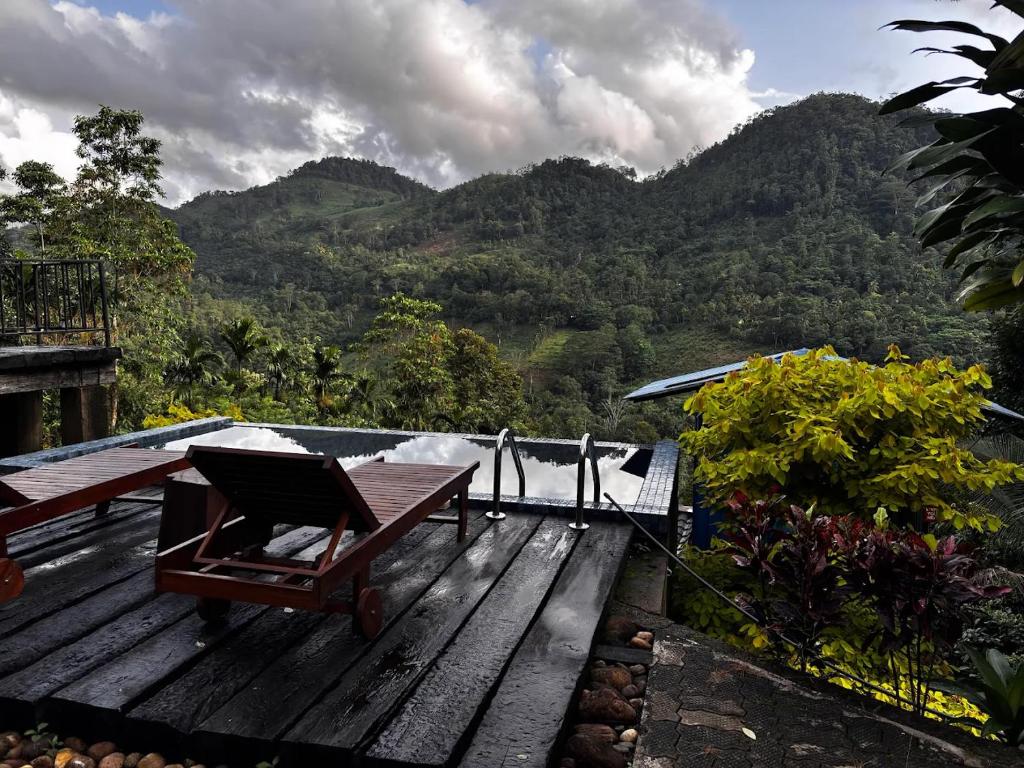 a deck with a table and a view of a mountain at The Nook in Deraniyagala