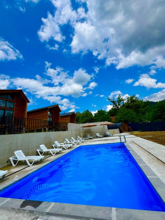 a swimming pool with lounge chairs next to a house at Sioni Hillside Cottages in Sioni