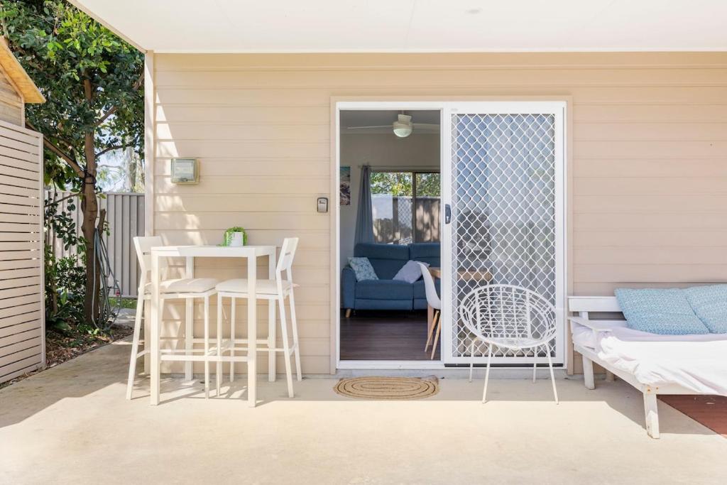 a patio with a table and chairs and a door at Kingscliff Spacious Beach Cottage in Kingscliff