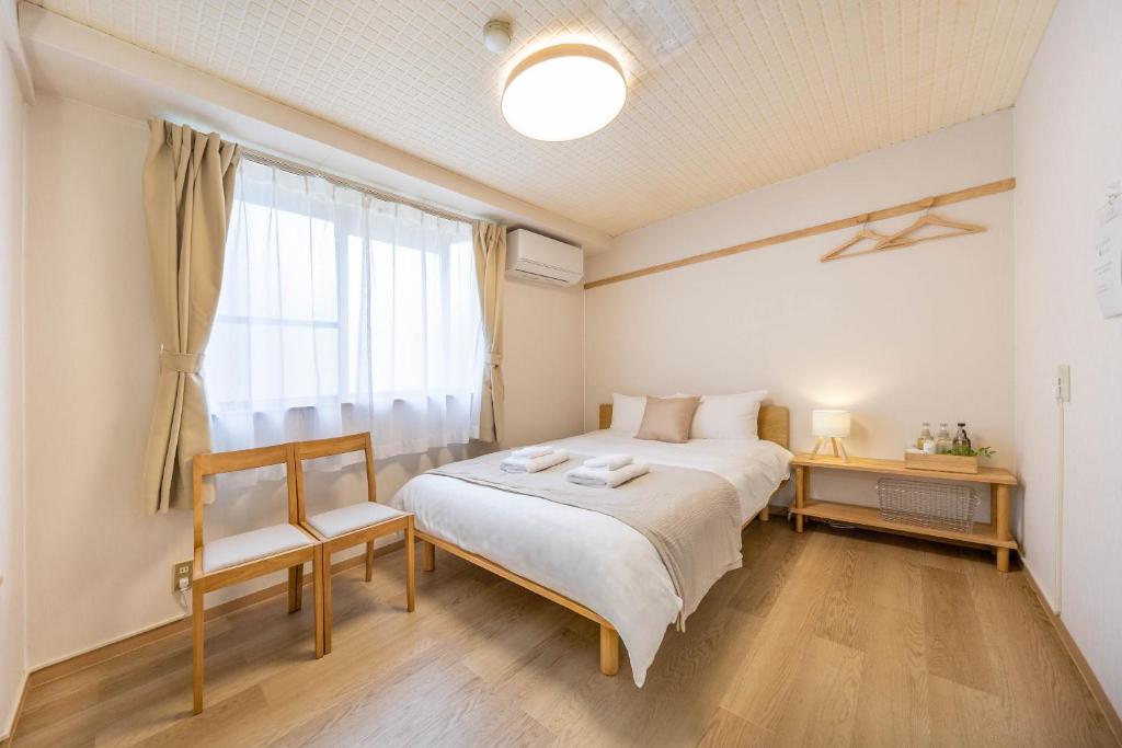 ein Schlafzimmer mit einem großen Bett und einem Fenster in der Unterkunft Comfy Stay Sakuramachi in Nara