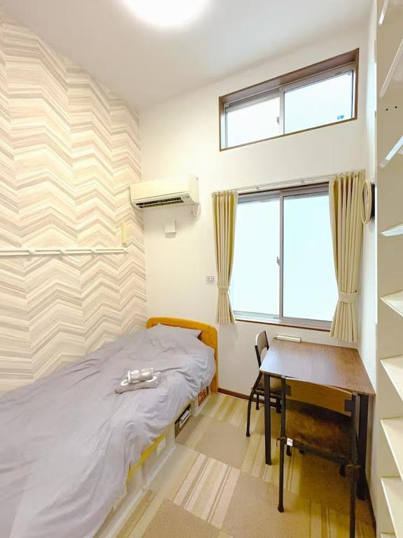 a bedroom with a bed and a desk and a window at The Scene Fuchinobe in Sagamihara