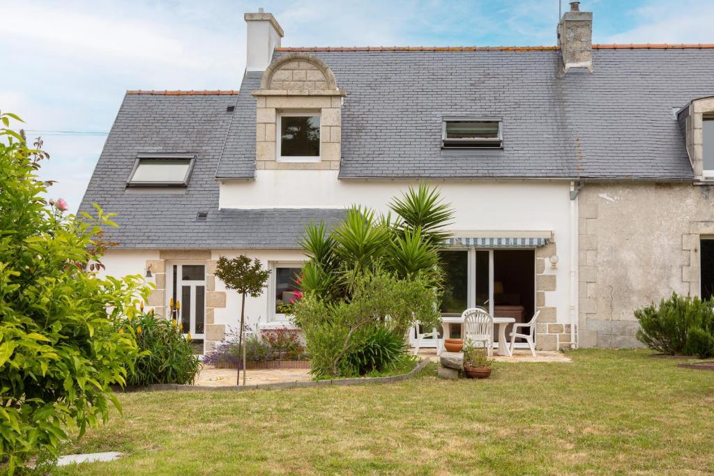 a large white house with a yard at Une Chambre À Lestriguiou in Plomeur
