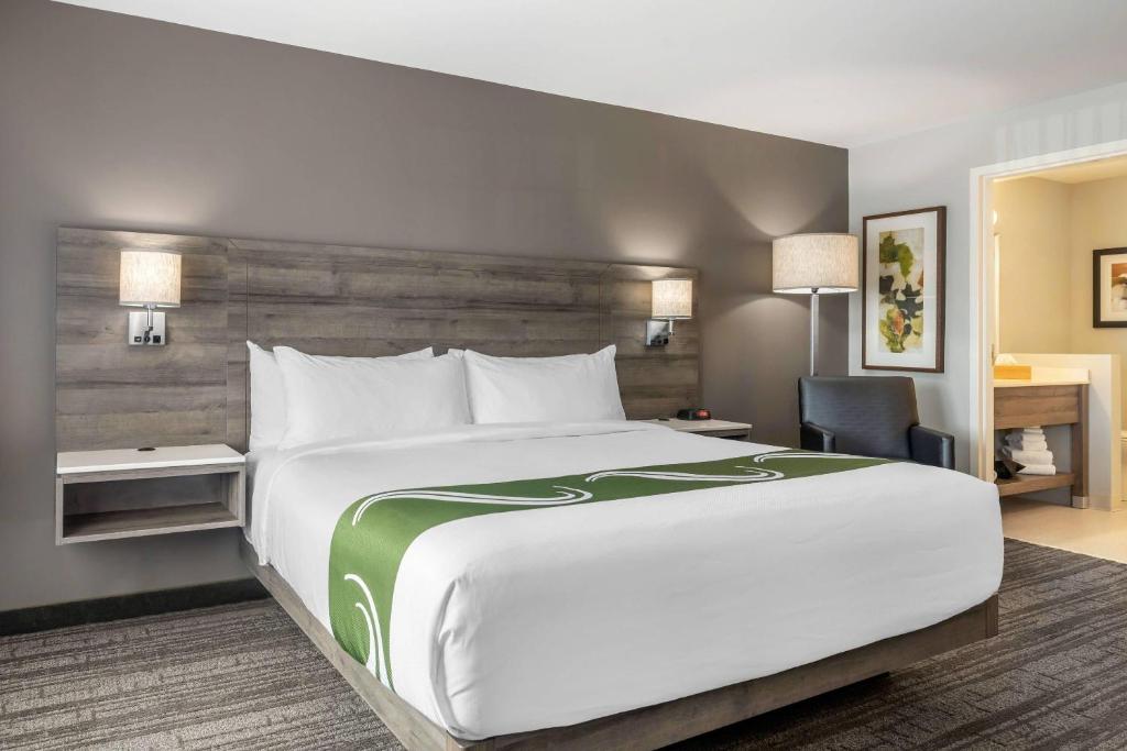 a hotel room with a large bed and a desk at Amsterdam Inn & Suites, an Ascend Collection Hotel in Fredericton