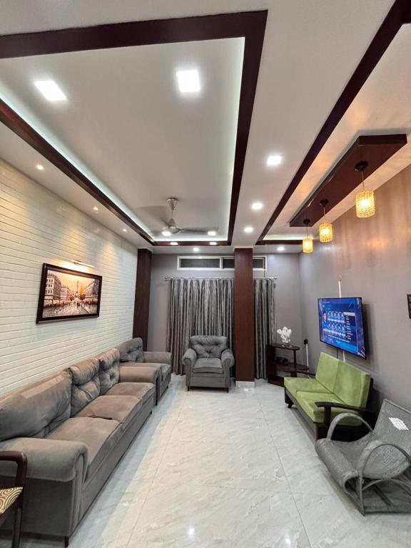 a large living room with couches and a tv at Unique Nest Homestay in Guwahati