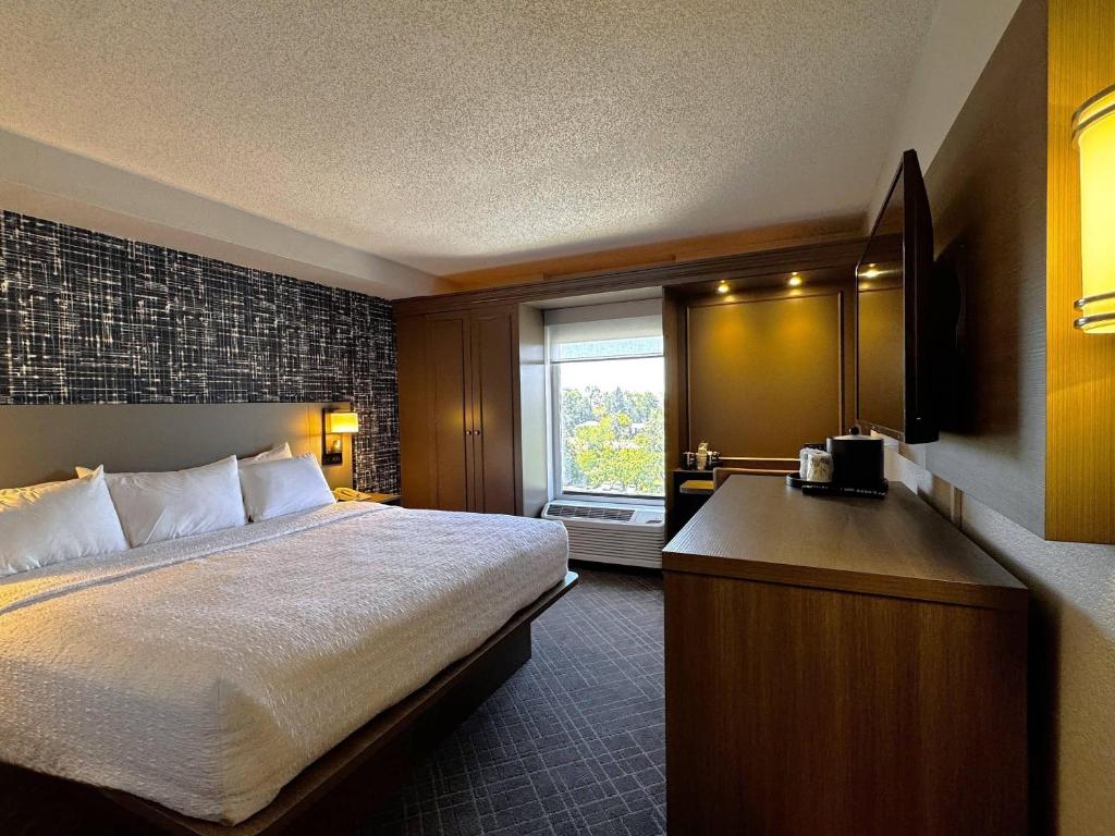 a hotel room with a bed and a window at Pittsburgh Airport Inn and Suites in Coraopolis