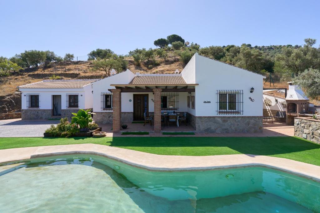 a house with a swimming pool in front of it at El Rincón de Esther in Cómpeta