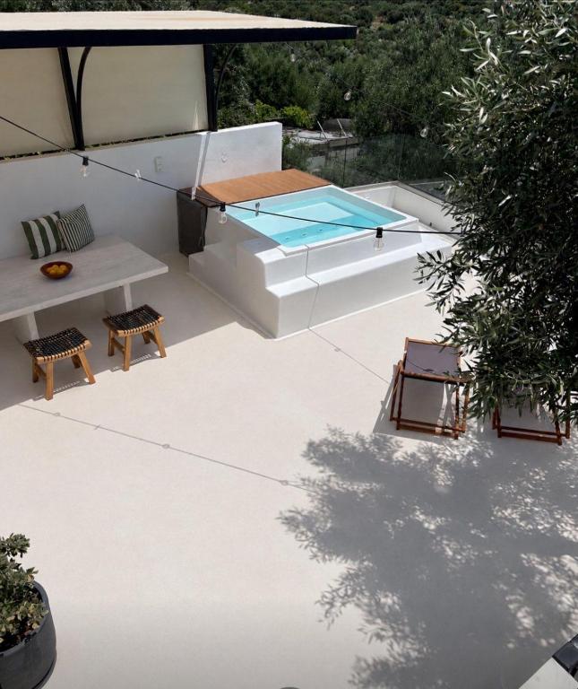 a patio with a hot tub and a table and chairs at Villa Mourelaki in Ierapetra