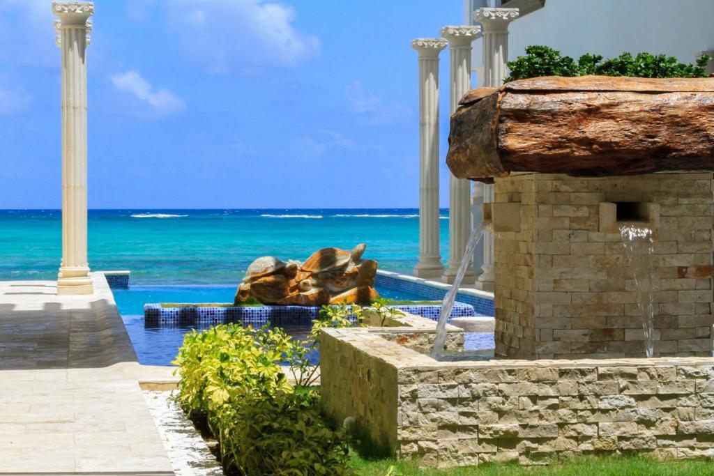 una piscina con una fuente frente al océano en Cielo Maya Beach Tulum, en Tulum