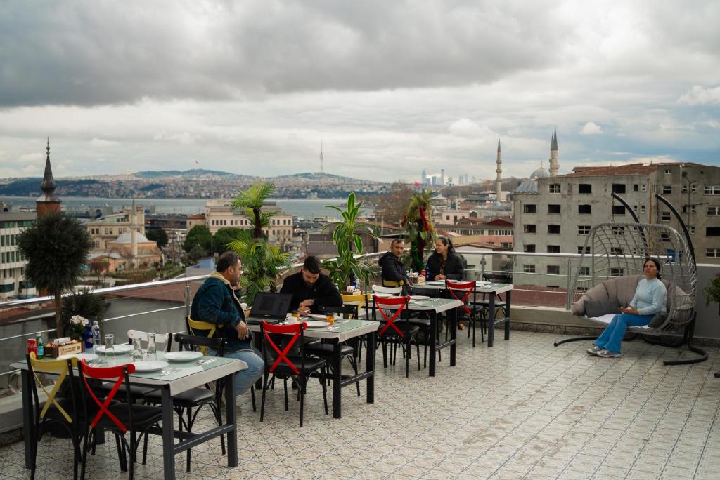 a group of people sitting at tables on a roof at Golden Horn Life Hotel- FULL BOARD in Istanbul