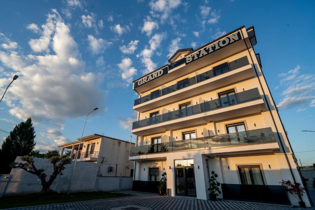 a hotel with a sign on the side of a building at Grand Station Hotel in Shkodër