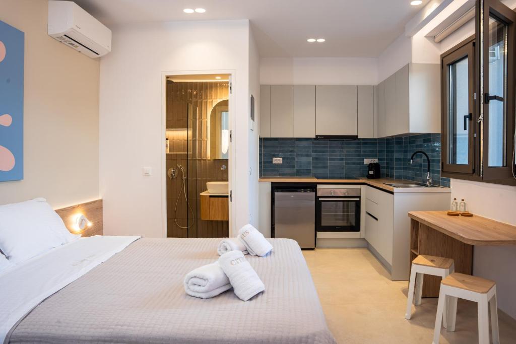 a bedroom with a large bed with towels on it at Citrus 5 Urban Studios in Mastambás