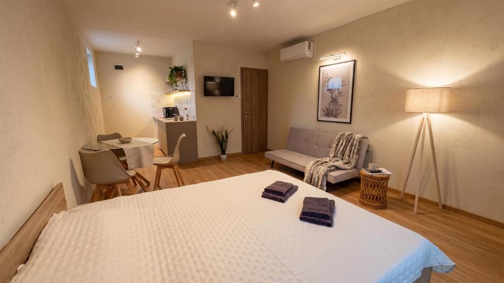 a bedroom with a bed and a living room at Sétány Apartman-és Vendégház in Tiszafüred