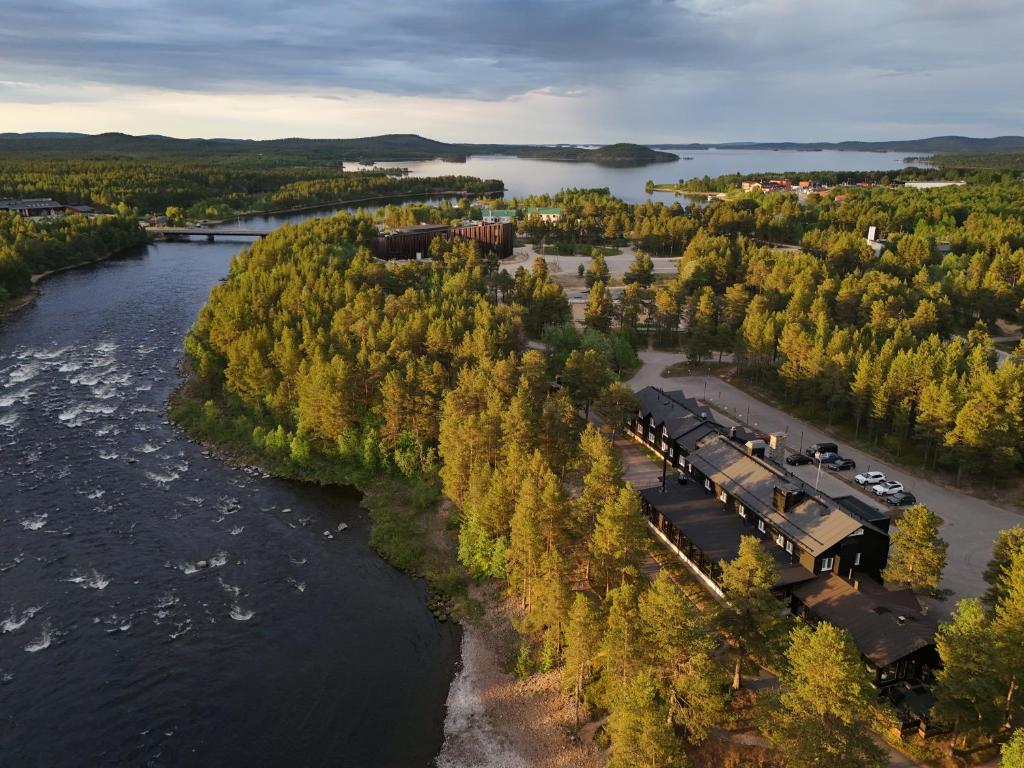 an aerial view of a train on tracks next to a river at Wilderness Hotel Juutua in Inari