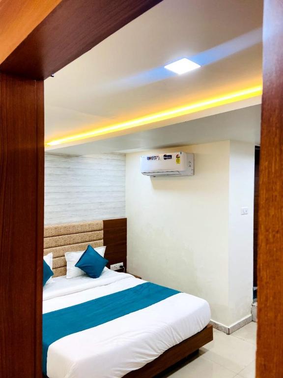 a bedroom with a bed with blue and white sheets at Hotel Namaste Ac Rooms in Vadodara