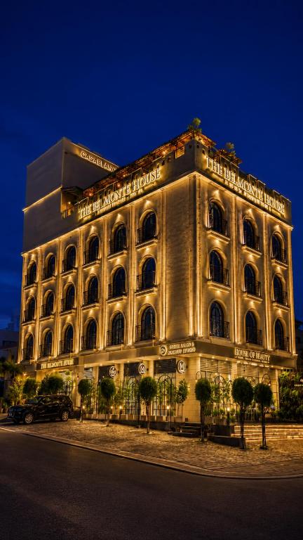 a large building is lit up at night at The Belmonte House by Noventa - Rooftop Pool Hotel in Udaipur in Udaipur