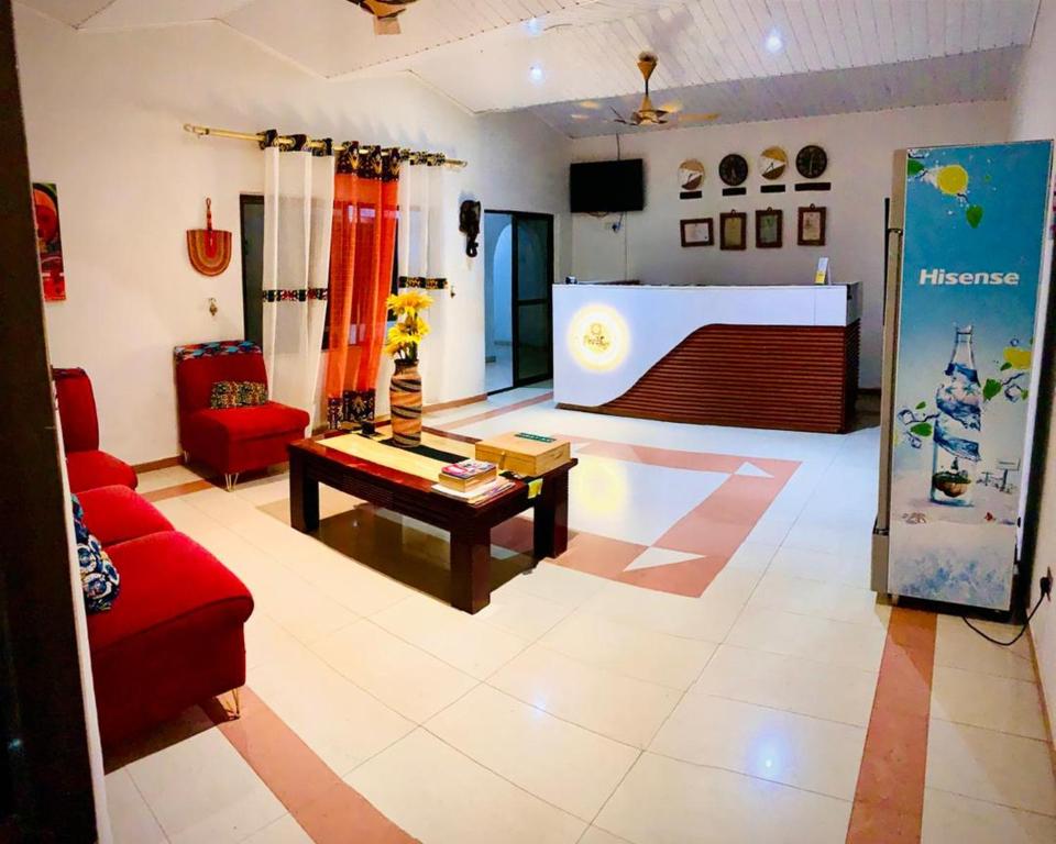 a living room with a red couch and a table at PRESTIGE Guesthouse ,Ksi in Kumasi