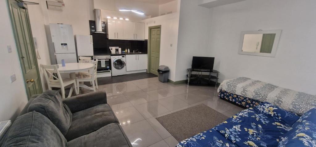 a living room with a couch and a table and a kitchen at Rear Borough Suite in Ipswich