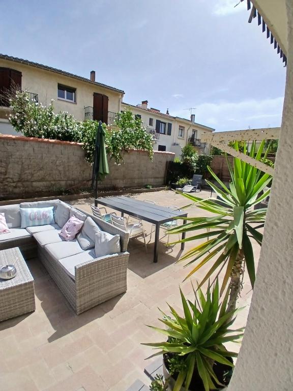 eine Terrasse mit einem Sofa und einem Tisch und einigen Pflanzen in der Unterkunft Studio Chill in Canet-en-Roussillon