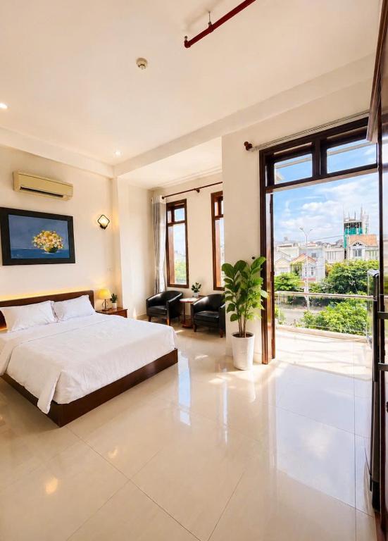 a bedroom with a bed and a large window at Hani Motel Da Nang in Danang