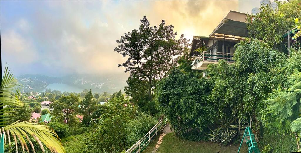 a house on the side of a hill with trees at Magpie Retreat in Bhīm Tāl