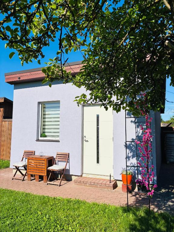 a small white house with a table and chairs at SweetHome in Limbaži