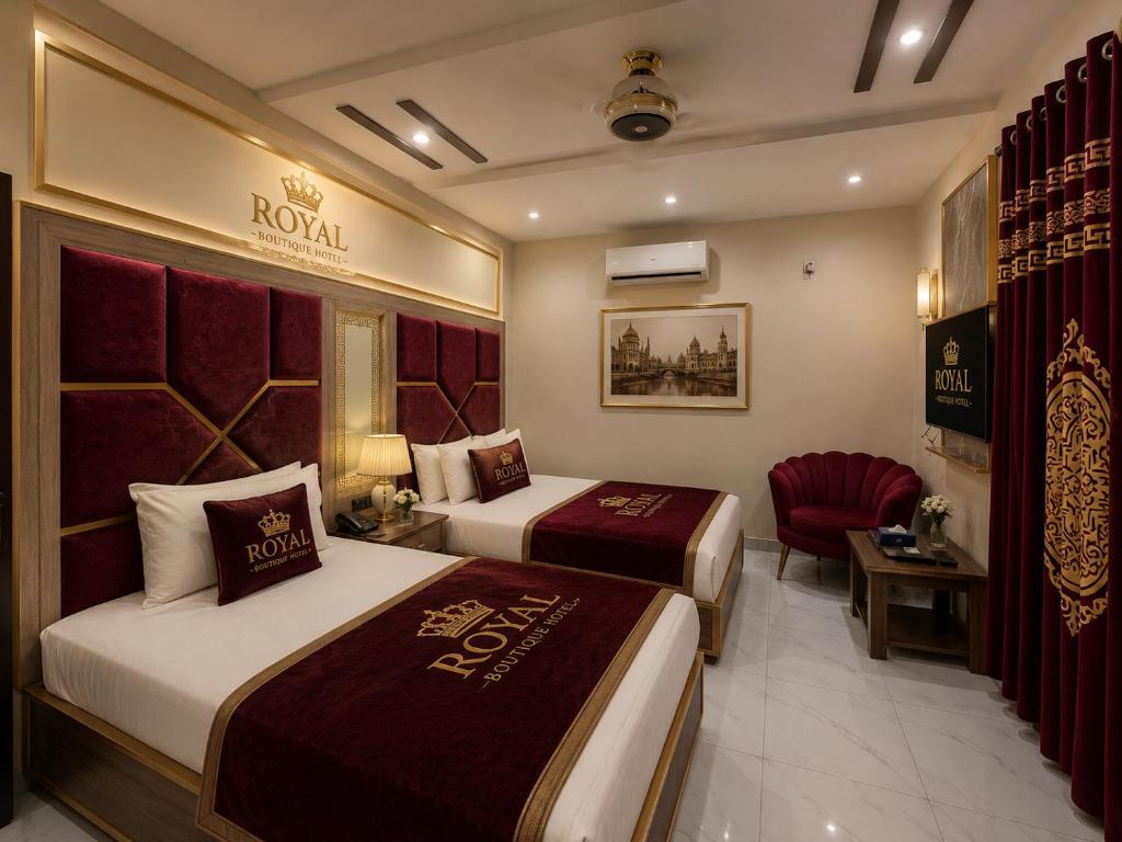 a hotel room with two beds and a chair at Royal Boutique Hotel Lahore in Lahore