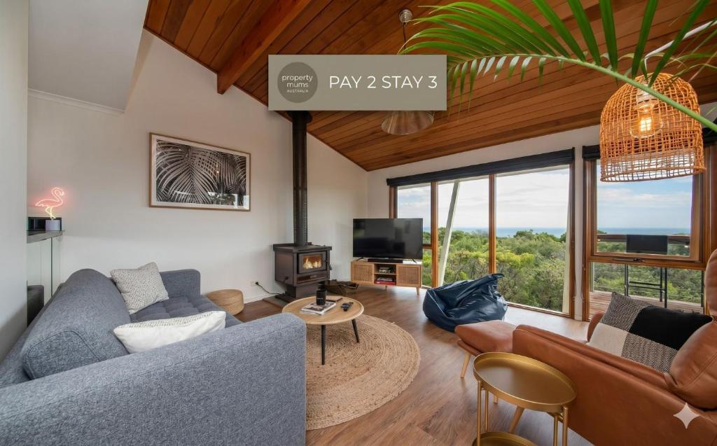 a living room with a blue couch and a table at TJ's Tree House with Ocean Views in Cape Schanck