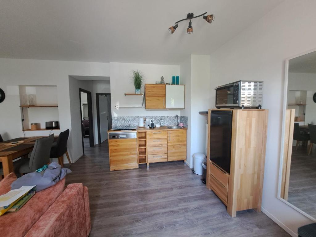 a living room with a kitchen with a couch and a table at Ferienwohnungen Leber in Bad Neustadt an der Saale