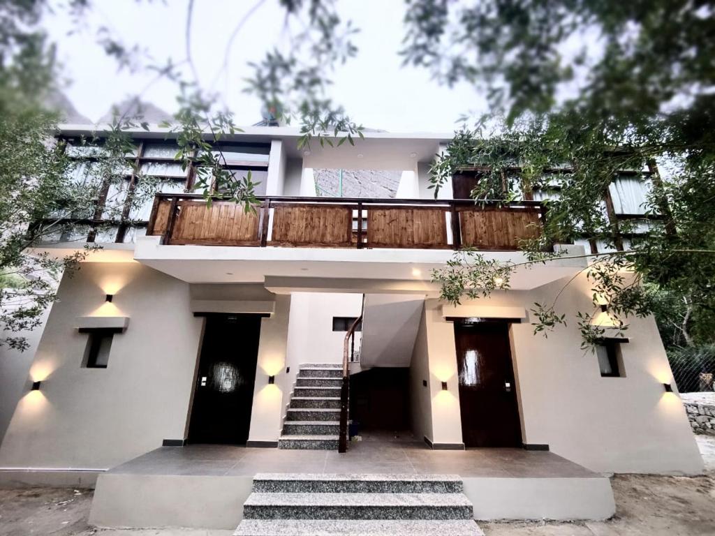 a white house with stairs and a balcony at Desert Oasis Camp And Resort in ladakh