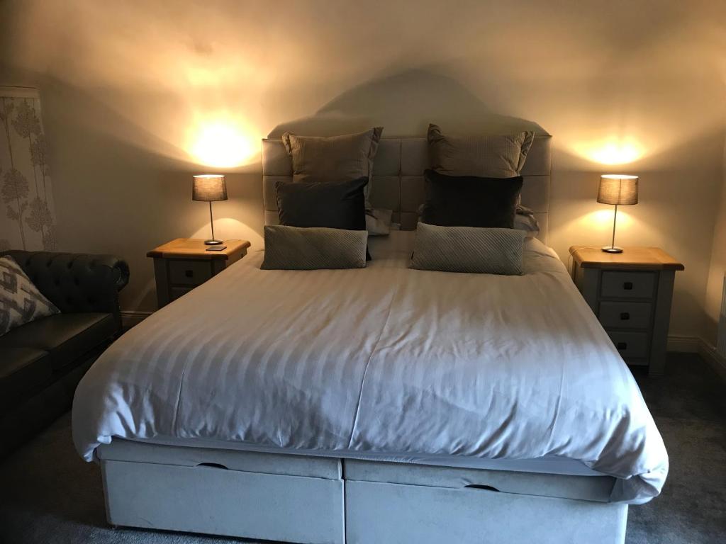 a bedroom with a large white bed with two lamps at The Bridge in Ballyconnell