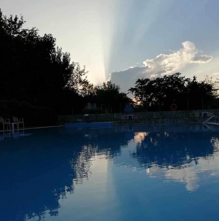 a swimming pool with a reflection of the sky at Meteora Garden in Kalabaka