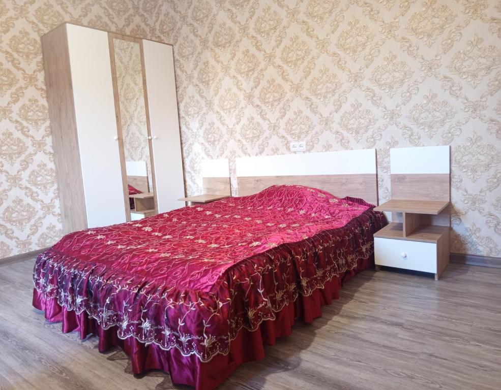 a bedroom with a bed with a red bedspread at Full moon in Yerevan