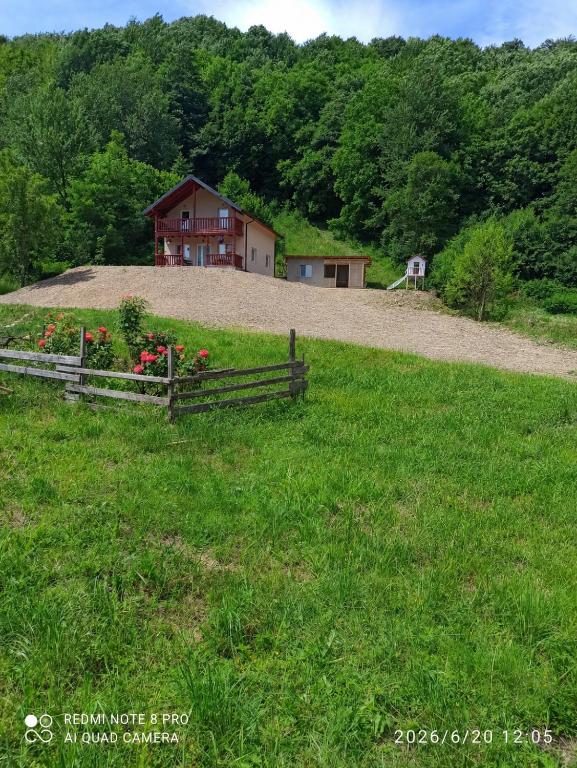 a house on top of a hill with a fence at Liziera Cabin Malaia in Malaia