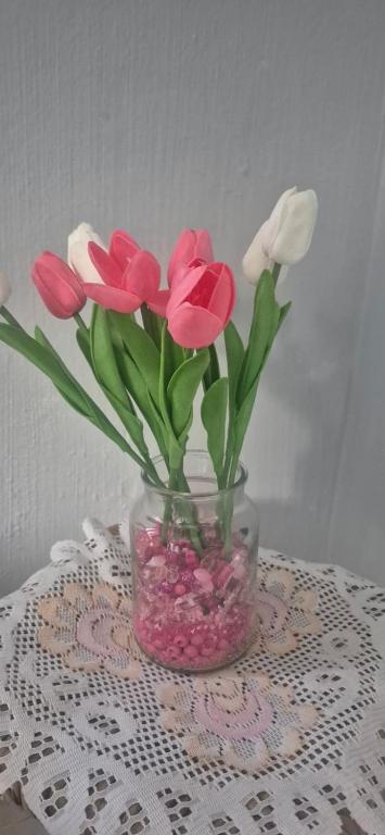 a vase filled with pink and white flowers on a table at Over the Rainbow Guest House in Hibberdene