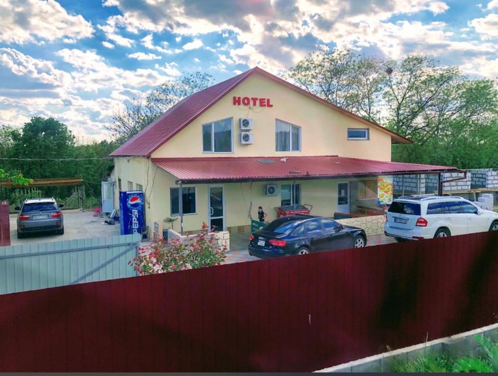 a hotel with cars parked in a parking lot at Comfort in Reni