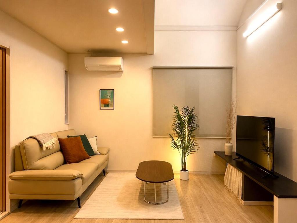 a living room with a couch and a tv at OTE HOUSE shime in Shime