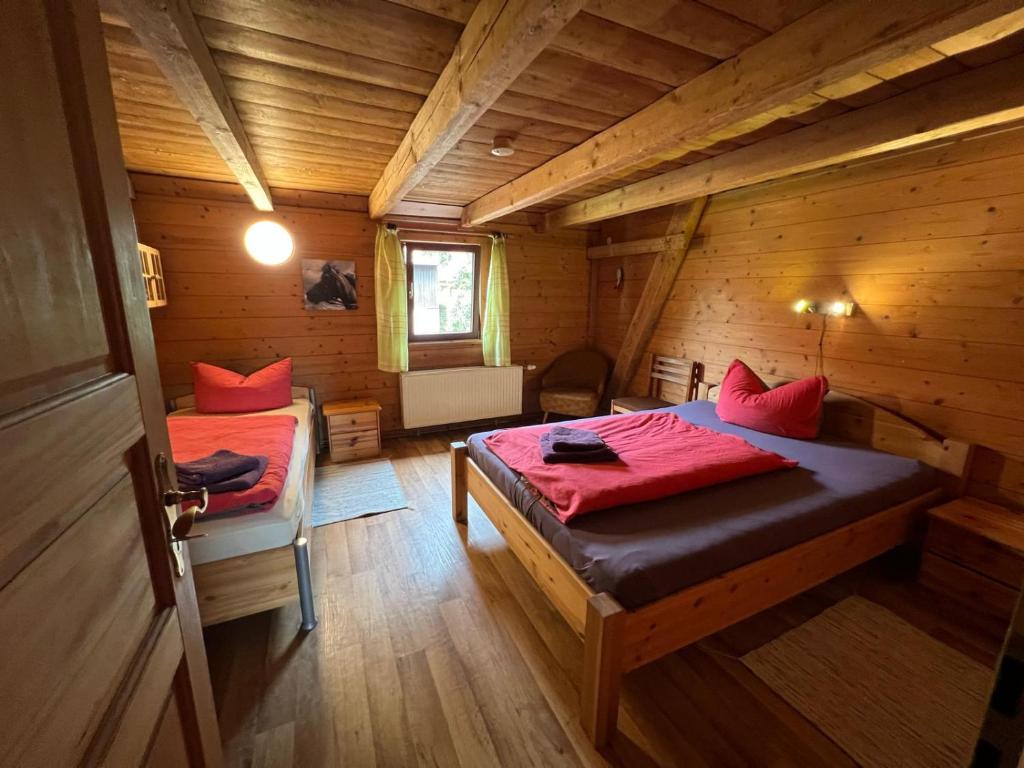 a bedroom with two beds in a wooden cabin at Reiter- und Ferienhof Wacker in Schöna