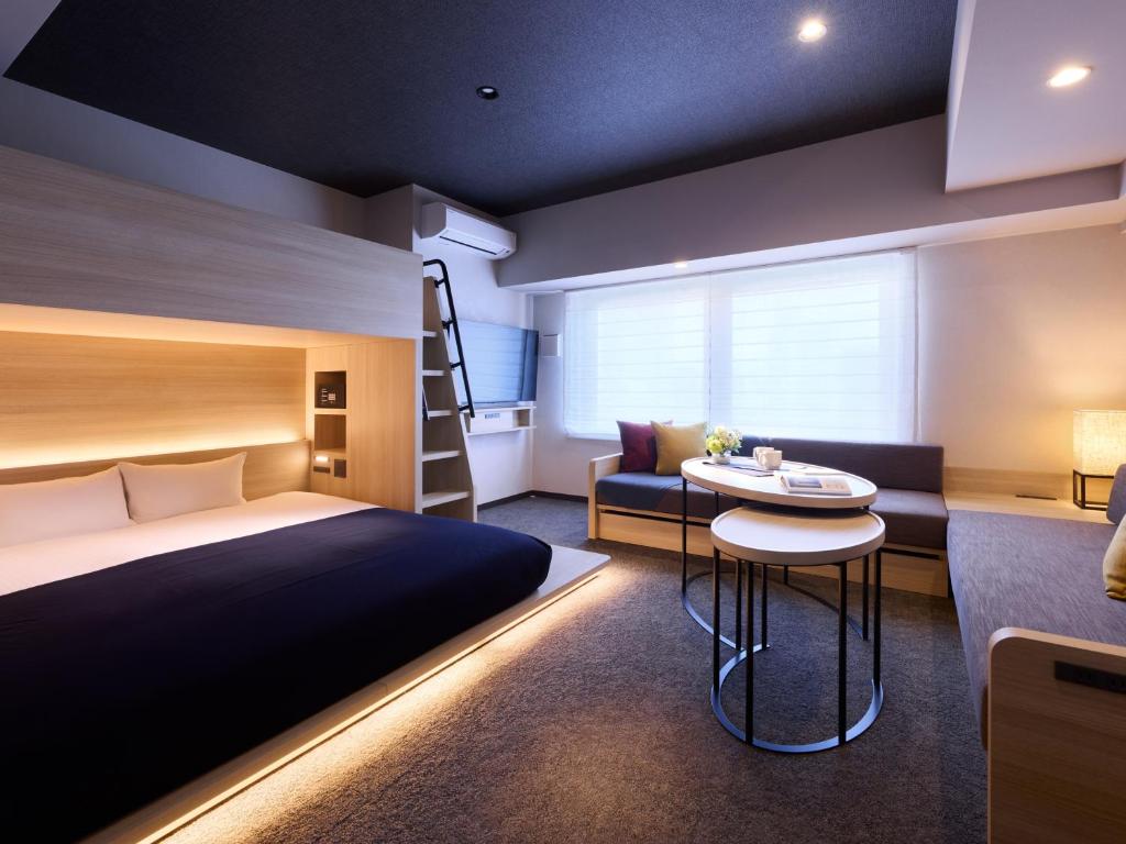 a bedroom with a bed and a bunk bed and a desk at Minn Namba South in Osaka