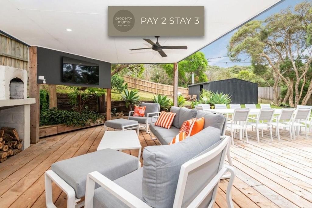 a patio with a couch and chairs on a wooden deck at Stratford by the Sea in Rye in Rye