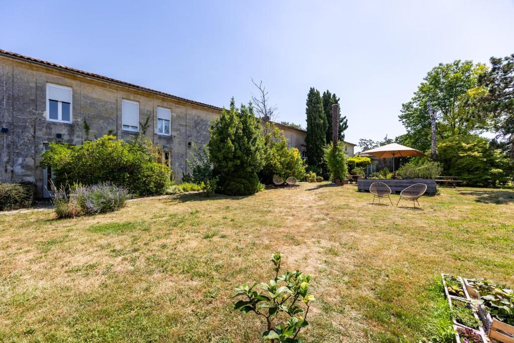 a yard with two chairs and a building at Chambres d'hôtes Château Cajus in Saint-Germain-du-Puch