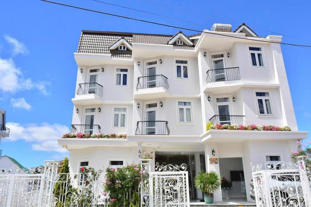a white building with white fences in front of it at Zanya villa & coffee in Da Lat