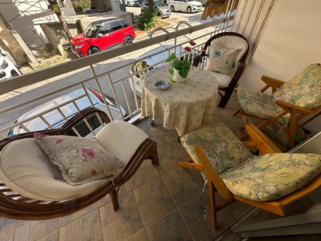 a balcony with a table and chairs and a table with a car at LADY E. in Kavála