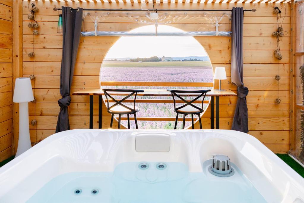 a tub in a room with a table and a field at Le Spa des lavandes panoramique in Valensole