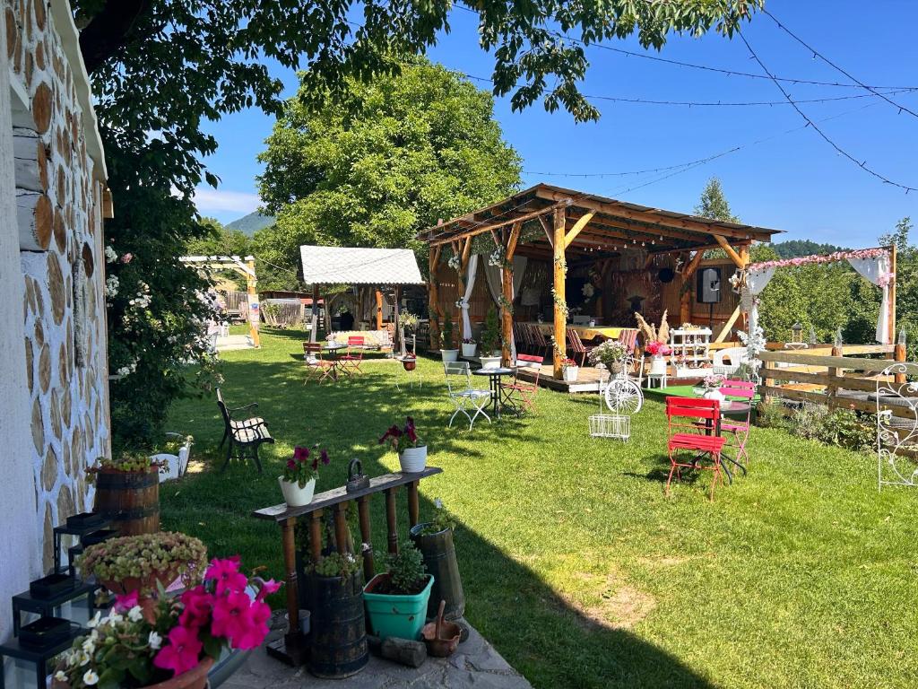 a garden with a pavilion and tables and chairs at Casa Verde in Vrîncioaia Negrileşti