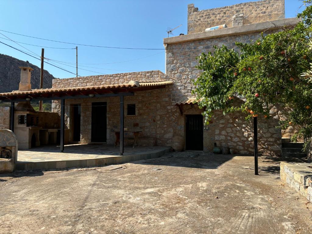 a stone building with a tree in front of it at Mani Spot Elmare in Okhiá