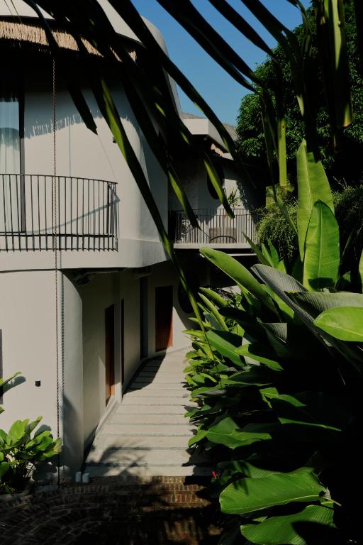 a building with a staircase leading up to it with plants at Makai Lombok in Selong Belanak