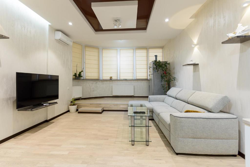 a living room with a couch and a tv at Apartment on Dragomirova in Kyiv