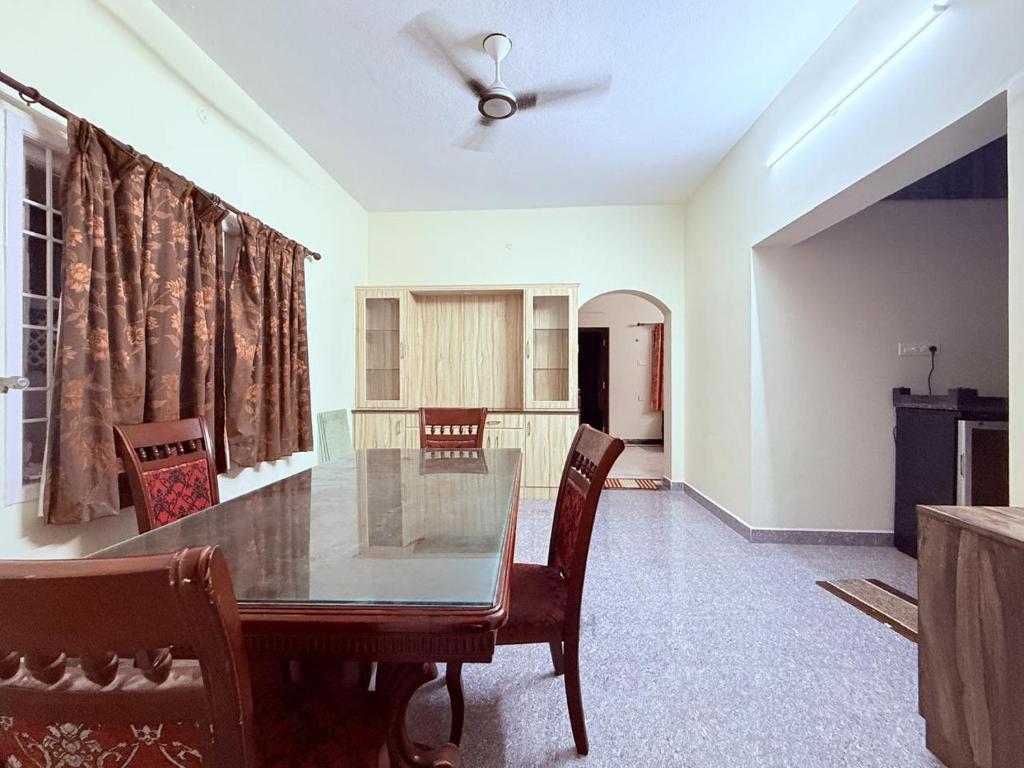 a dining room with a table and a ceiling fan at CK Beach House in Chennai